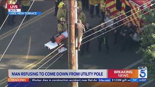 Man refusing to come down utility pole