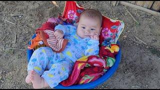 Single mother with small child struggles to take her child to cut bamboo