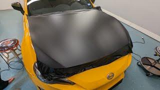 Before & after hood wrapped in Hexis Deep Black Satin vinyl wrap.