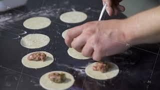 Cook putting minced meat on dough. Art. Close-up of professional chef applying minced meat for