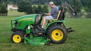 John Deere 2320 compact tractor mowing high grass