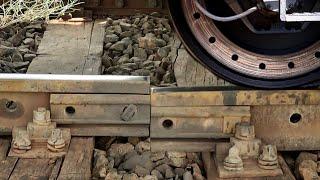 Train wheels on a bad rail connection. At medium speed on a siding.