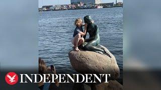 Tourist booed as she climbs Copenhagen's Little Mermaid statue despite warnings