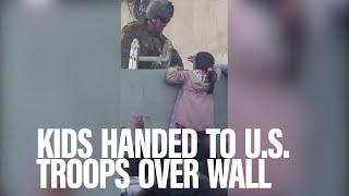 Raw video: See kids handed over wall to U.S. troops in Kabul