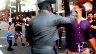 Smart ass gets punched by street performer!