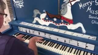 Merry-Go-Round Museum board member Ron Albert plays the new painted piano outside the museum on Thur