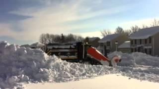 Snow plow plowing big piles at intersection