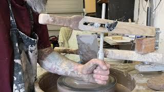 Centering clay using a, strong arm tool