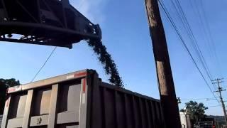 The conveyor of an asphalt mill loading a truck