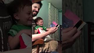 Baby Arthur laughing at a book of trains