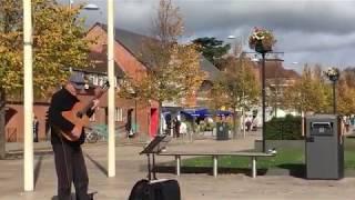 A Man Playing A Guitar At A Plaza in Stratford On Avon