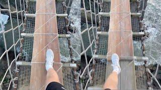 Hiker Crosses Rope Bridge Across Ocean Water