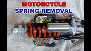 Spring removal on R6 motorcycle rear shock using ratchet straps for a spring compressor