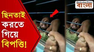 চলন্ত ট্রেনে জানলার বাইরে ঝুলছে অভিযুক্ত ছিনতাইকারী!যাত্রীদের এই কীর্তির ভিডিয়ো ভাইরাল