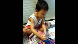 Kai is painting his own bus made of recycled box