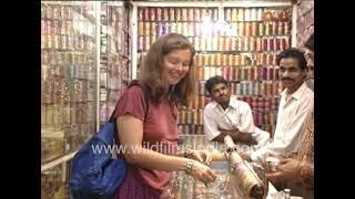 Foreign woman tourists go shopping in an Indian marketplace, looking at bangles and jewellery