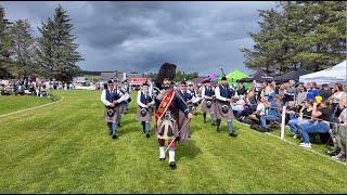 Drum Major Dyer leads Aberlour Pipe Band playing on the march during 2024 Dufftown Highland Games