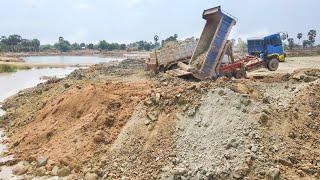 Amazing bulldozer and dump trucks filling land into the water