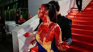 Woman clad in Ukrainian colours pours fake blood on herself at Cannes Film Festival