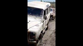 Land Rover Defender 110 pulling two trucks through mud!