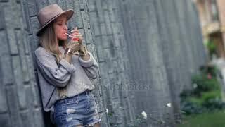 Woman smoking and leaning on the loft brick wall —