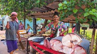 "Vibrant Village Fish Market: Skillful Fish Cutting and Fresh Catches"