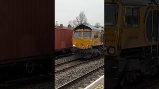 66021 powers out of Oxford as 66741 passes