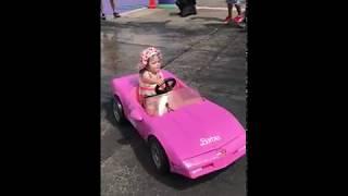 little girl doing burnouts in toy car