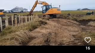 Golf course construction, Excavator slabbing with marram fork.